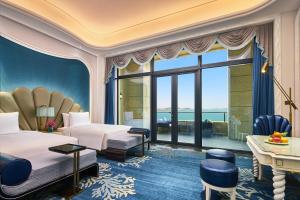 Cette chambre d'hôtel comprend deux lits et offre une vue sur l'océan. dans l'établissement Wanda Vista Qingdao Movie Metropolis, à Huangdao