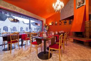 a restaurant with tables and chairs and a chandelier at Villa Cyriel in Contes