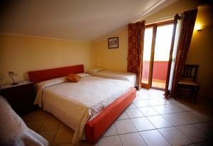 1 dormitorio con 2 camas y ventana en B&B Casalotto Inn, en Aci SantʼAntonio