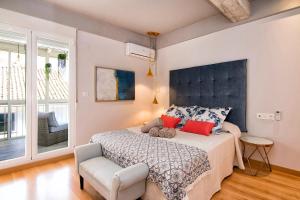 Un dormitorio con una cama grande y una silla. en tuGuest Clave de Sol Apartment, en Granada