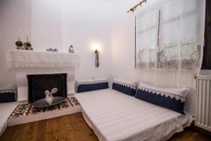 a living room with two beds and a fireplace at Dreaming House in Nea Vrasna