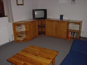 a living room with a tv and a wooden table at Haus Anne in Ellmau