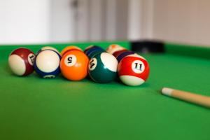 a group of billiard balls on a green table at Gîte Coeur de Beurre in Louette-Saint-Denis