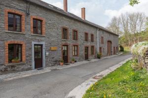 a brick building with doors and windows on a street at Gîte Coeur de Beurre in Louette-Saint-Denis