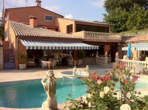 a pool with a statue in front of a house at Villa Cyriel in Contes