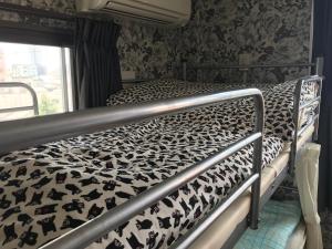 熊本市にあるゲストハウス　ティガの黒と白のマットレスが備わる客室のベッド1台分です。