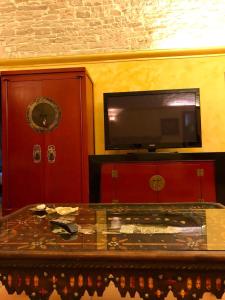 Cette chambre dispose d'une table et d'une télévision murale. dans l'établissement L'Orecchietta 2.0, à Ruvo di Puglia