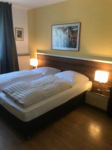 ein Schlafzimmer mit einem großen Bett mit zwei Lampen in der Unterkunft Apartmenthaus Sonnen in Düsseldorf