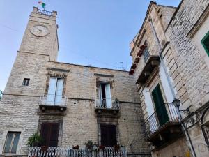 un grand bâtiment en briques avec une tour d'horloge dans l'établissement L'Orecchietta 2.0, à Ruvo di Puglia