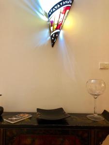 une lumière sur un mur à côté d'un verre de vin dans l'établissement L'Orecchietta 2.0, à Ruvo di Puglia
