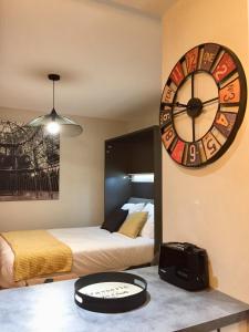 a room with two beds and a large clock on the wall at Les Mermes à Veigy 10mn de Genève in Veigy-Foncenex