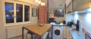a kitchen with a washing machine and a table at Les Mermes à Veigy 10mn de Genève in Veigy-Foncenex