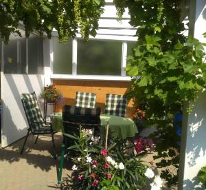 a patio with two chairs and a table and flowers at Ferienwohnung Meyer mit Garten in Haundorf