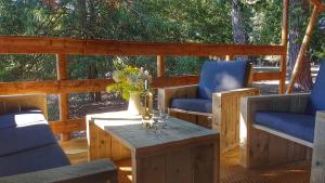 une terrasse couverte avec 2 chaises et une table. dans l'établissement Le Lodge du Domaine Saint Martin, à Flassans-sur-Issole