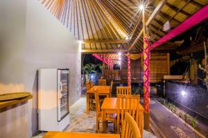 een restaurant met tafels en stoelen en een koelkast bij Sea Bridge Villa Ceningan in Nusa Lembongan