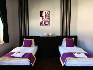 2 Betten in einem Zimmer mit lila und weißen Laken in der Unterkunft Ferienwohnung Alabama in Lutherstadt Wittenberg