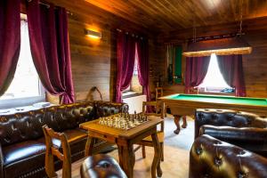 una sala de estar con sofás de cuero y una mesa con ajedrez en Horský hotel Kozubová en Dolní Lomná
