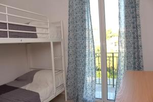 ein Schlafzimmer mit Etagenbetten und ein Fenster mit Balkon in der Unterkunft Casa Laura in Imperia