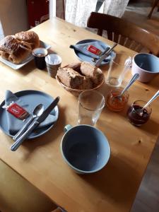 einen Tisch mit Tellern, Utensilien und Brot darauf in der Unterkunft ARÔMA - anciennement l'Instant B in Blain