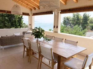 a dining room with a wooden table and chairs at Luxury Family Beach Front Villa - SUNDAY BEACH HOUSE in Slatine