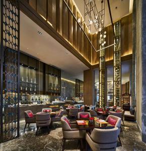 un restaurant avec des tables et des chaises ainsi qu'un bar dans l'établissement Wanda Vista Qingdao Movie Metropolis, à Huangdao