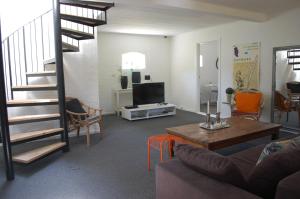 uma sala de estar com uma escada, um sofá e uma mesa em Fredensborg Guesthouse em Fredensborg