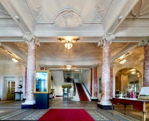 a large lobby with columns and a red rug at Hotel Schweizerhof Luzern in Lucerne