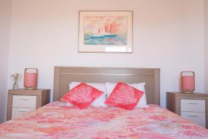 サン・ロケにあるPopulo Beach Houseのベッドルーム1室(赤い枕2つ付きのベッド1台付)