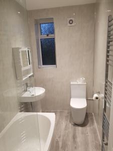 a bathroom with a toilet and a sink and a tub at Sighthill 3 Bedrooms with Private Garden in Edinburgh
