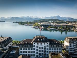a city with a lake and mountains at Hotel Schweizerhof Luzern in Lucerne