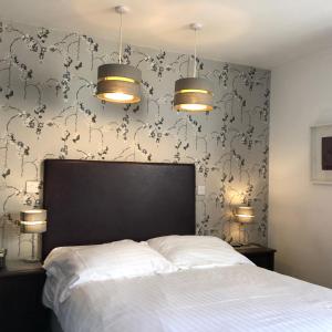 a bedroom with a bed and two lights and a wall at Newton House Oxford in Oxford