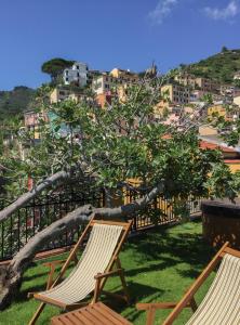 two chairs sitting on the grass in front of a tree at Agave Room Rental in Riomaggiore