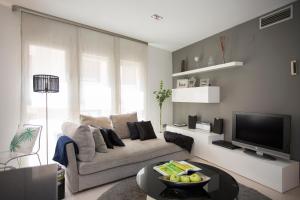 a living room with a couch and a tv at SingularStays Poeta Querol in Valencia