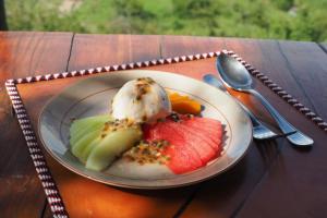 a plate of fruit and ice cream on a table at Saruni Eagle View in Naboisho