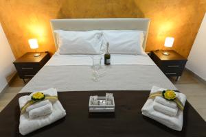 un letto con asciugamani e una bottiglia di vino sopra di Dimora Civitas Severiana a Montescaglioso