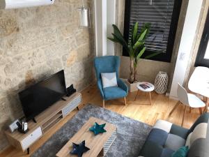 un soggiorno con TV e sedia blu di URBAN VIEWS Terrace - Duplex Apartment "Luis I" a Porto