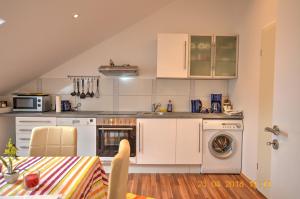 a kitchen with white cabinets and a washer and dryer at Ferienwohnung"VIP MUNICH ALBATROS DE LUXE" in Kirchheim
