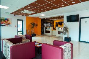 a lobby with two chairs and a table in a room at Pensiune Confort Morosanu in Şinca Veche