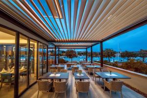 un ristorante con tavoli, sedie e finestre di Hotel Maritime a Krk