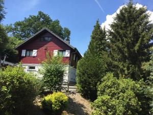 a red house in the middle of some trees at Chalet Grand Coo in Stavelot