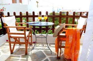 a table and chairs on a patio with two glasses of wine at Filoxenia Studios in Kithnos +29 photos