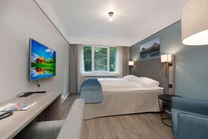 a hotel room with a bed and a desk at Førde Hotel - Unike Hoteller in Førde
