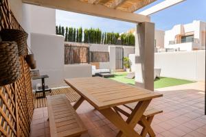 een houten tafel en stoelen op een patio bij Can Marcel in Cala Tarida