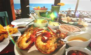 a table with a plate of shrimp and other food at Puerto Nuevo Baja Hotel & Villas in Rosarito