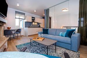 ein Wohnzimmer mit einem blauen Sofa und einem Tisch in der Unterkunft Harmony In Blue in Rovinj