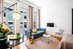 a living room with a blue couch and windows at The A5 Smart Luxury Studios in Porto