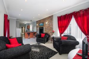 a living room with two couches and red curtains at 2 on Bashee in Port Elizabeth