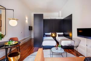 a hotel room with two beds and a couch at The A5 Smart Luxury Studios in Porto