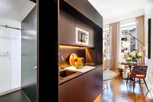 a kitchen with a sink and a table in a room at The A5 Smart Luxury Studios in Porto