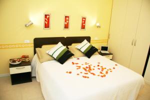 - une chambre avec un lit blanc orné de fleurs dans l'établissement Residence Opera, à Rimini